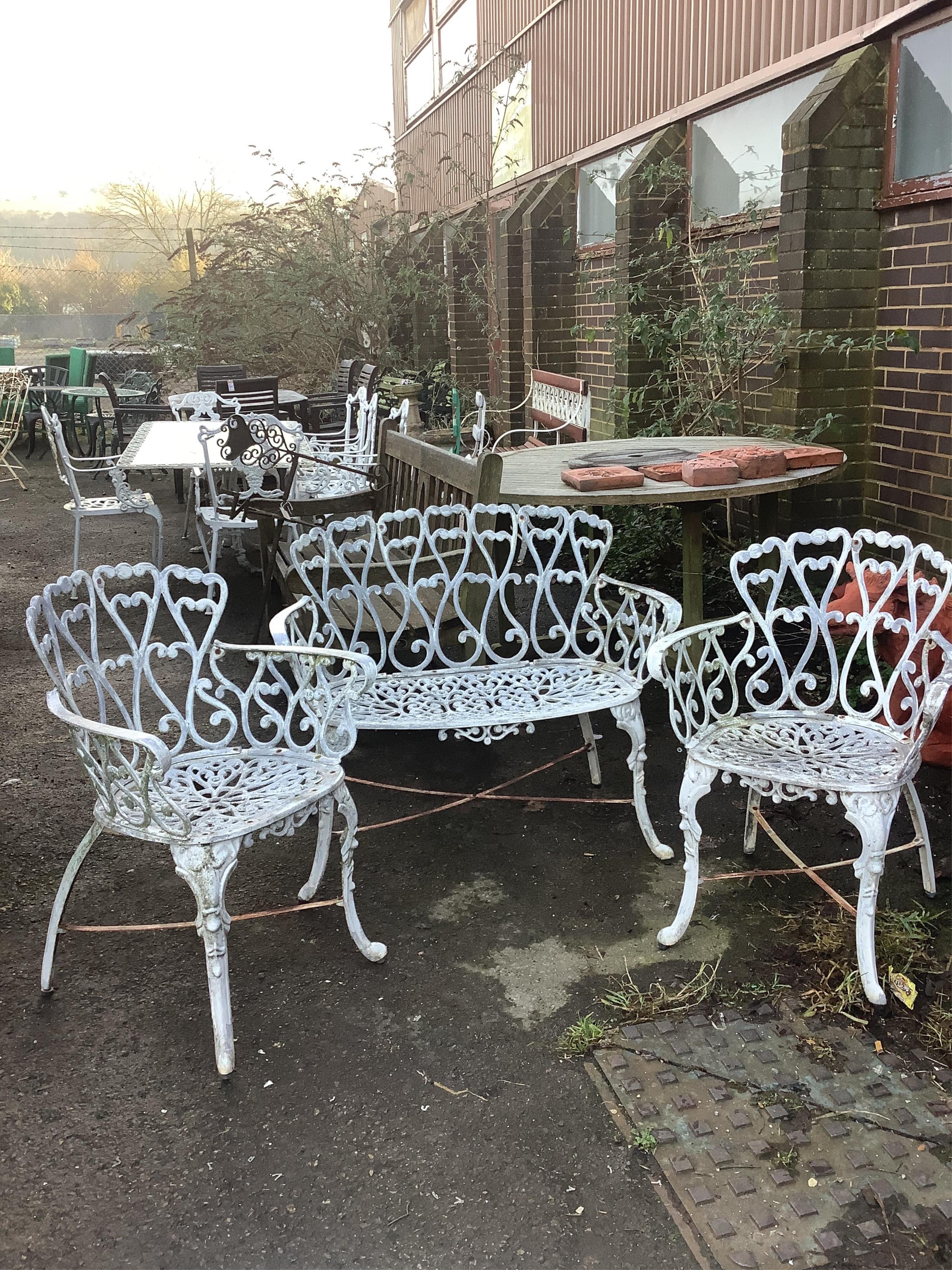 An aluminium garden table, diameter 80cm, height 66cm with two chairs and a bench. Condition - fair